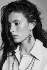 Pendientes largos colgantes con forma de serpiente enroscada. Presentan un acabado metálico en tono dorado envejecido y partes del cuerpo cubiertas de pequeños cristales oscuros.