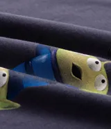 Remera de algodón con cuello redondo y manga corta, de corte holgado. Presenta un estampado frontal de los Aliens de Toy Story siendo atrapados por una garra mecánica.