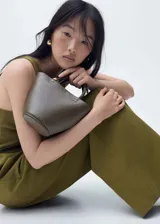 Bolso tipo baguette con estampado de cebra en blanco y negro, asa corta y detalles metálicos dorados.