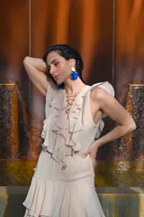 Vestido largo color beige con volados en el escote y falda escalonada.