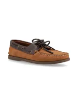Mocasines tipo náutico de cuero color marrón tostado, con detalles en cuero marrón oscuro en el cuello y cordones decorativos. Presenta costuras reforzadas en la puntera y suela plana de goma.