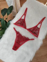 Conjunto de lencería compuesto por un corpiño triangular de encaje con tirantes finos y una bombacha tipo colaless de encaje a juego.