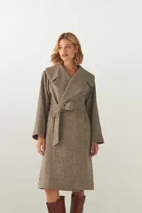Tapado largo de lana con cuello solapa, cierre cruzado con cinto ajustable a la cintura y mangas largas. Presenta un diseño de textura jaspeada en tonos tierra.