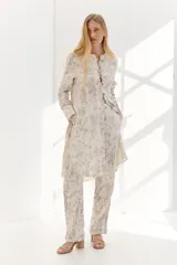 Pantalón largo de corte recto, color crudo con estampado abstracto en tonos grises.