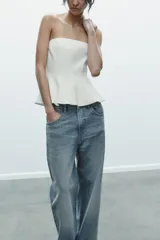 Top color amarillo claro, sin mangas y con escote recto. El bajo tiene un acabado peplum.