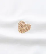 Remera blanca de algodón con cuello redondo y mangas cortas. Presenta pequeños corazones bordados con lentejuelas en el frente.