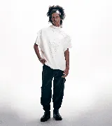 Pantalón babucha unisex de pana color negro, corte oversize, bajo puño con botón y bolsillo plaqué asimétrico en laterales.