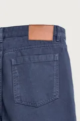 Pantalón relaxed fit azul marino confeccionado en tejido de algodón con estructura, de estilo clásico con cinco bolsillos y cierre frontal con cremallera y botón.