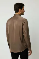 Camisa de poliéster color marrón, de corte holgado, con mangas largas, cuello camisero clásico y cierre frontal de botones.