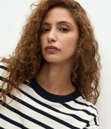 Blusa de corte boxy confeccionada en algodón, con diseño de rayas horizontales, cuello redondo de punto en color contrastante y mangas cortas.