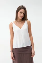 Musculosa bordó de tejido satinado, con escote en V y breteles con detalle de nudos en los hombros.