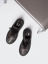 Borcego de punta redonda con efecto cuero desgastado, cordones y tira de velcro frontal. Cuenta con suela track y herrajes metálicos.