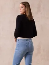 Cardigan tejido en hilado fino color blanco, marca Cable & Gauge. Abertura central con broche interno y terminación ondulada.