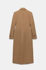 Abrigo largo entallado de Zara Woman Collection, confeccionado en mezcla de lana color tostado. Presenta cuello con solapa de muesca, mangas largas, bolsillos con solapa en el frente, forro interior y cierre frontal de dos botones oscuros.