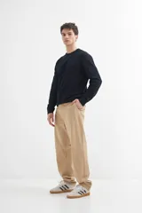 Sweater de punto color naranja claro jaspeado, con cuello redondo y mangas largas.