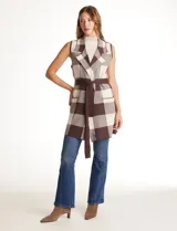 Chaleco tejido largo de la marca Absolutely Famous, con estampado a cuadros en tonos marrón, beige y blanco. Presenta cuello con solapa, abertura central, bolsillos aplicados en la parte delantera, pasadores en la cintura con lazo de ajuste y un tajo central en el ruedo trasero.