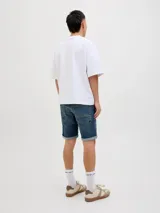 Bermuda de jean azul con efecto gastado y dobladillo revuelto en las piernas, de corte clásico.
