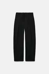 Pantalón tiro alto negro, con cintura elástica ajustable con cordones, bolsillos delanteros y detalle de pliegues en la parte frontal.