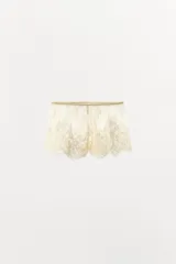 Shorts semitransparentes de encaje suave con tiro medio, cintura elástica y bordados florales a tono.