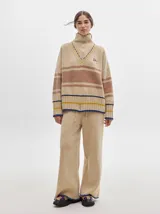 Pantalón de punto con textura tipo terciopelo, de corte ancho y holgado. Presenta cintura elástica con cordón de ajuste y detalle de pespuntes decorativos en los laterales.