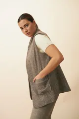 Chaleco color crema con solapas, corte entallado y bolsillos plaqué.