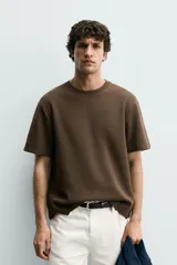 Camiseta relaxed fit color marrón, confeccionada en tejido con estructura, cuello redondo y manga corta.