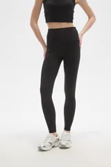 Calza deportiva de poliamida, color negro, con diseño al cuerpo y cintura alta.