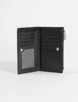 Billetera de cuero vegano color verde claro, con cierre superior y aplique metálico con logo en la parte frontal.