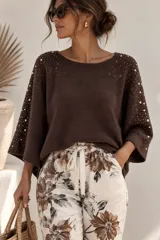 Sweater marrón de tejido de punto con mangas murciélago anchas, escote redondo y detalles de perlas y strass aplicados en los hombros y mangas.