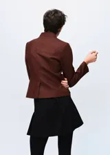 Chaqueta de mezcla de lana color marrón con cuello mao, cierre frontal abotonado y cuatro bolsillos de parche con solapa en la parte delantera.