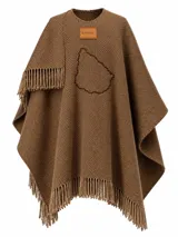 Ruana de punto color chocolate, con flecos en el ruedo, detalle de aplique de cuero con la marca Bagual y bordado en el pecho con la silueta del mapa de Uruguay.