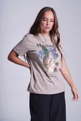 Remera blanca de algodón con estampado de flores de magnolia y texto en negro.