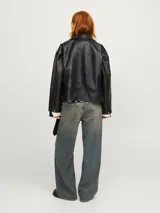 Campera estilo biker de cuero sintético negro con solapas anchas, cierre frontal cruzado, bolsillos con cremallera y cinturón ajustable en el dobladillo inferior.