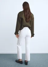 Jeans de tiro medio con diseño crop, estilo flare y bajo deshilachado, con cierre frontal de cremallera y botón, y cinco bolsillos.