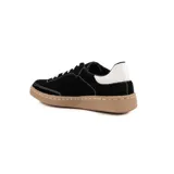 Championes de gamuza negra con costuras blancas a la vista, cordones blancos y suela de goma color caramelo. Presenta un detalle de cuero blanco en el talón.