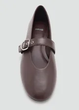 Zapato plano estilo Mary Jane color marrón, confeccionado en piel de ovino, con punta fina y tira en el empeine con hebilla metálica plateada.