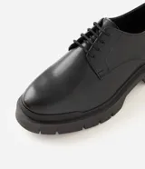 Zapato derby negro de poliuretano para hombre, con diseño robusto, puntera redondeada, cordones y suela tractorada.