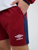Bermuda deportiva Umbro del Club Nacional de Football, color azul marino, con cordón ajustable en la cintura, bolsillos laterales, el escudo del club en una pierna y el logo de la marca en la otra.