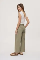 Pantalón verde militar de tiro medio y calce wide leg, con bolsillos laterales y cierre frontal con botón.