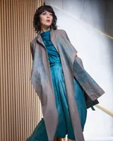 Túnica beige de gabardina de lana estampada con diseño abstracto en tonos ocre. Cuenta con cuello mao, bolsillos laterales y dos piezas a modo de bufandas que se pueden anudar de diferentes maneras.