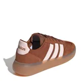 Championes urbanos Adidas modelo Barreda Decode, color marrón con detalles en rosado claro. Presentan una combinación de gamuza y material sintético, con las icónicas tres tiras laterales y suela de goma traslúcida.