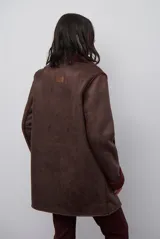Chaquetón de efecto cuero en color marrón, con interior y detalles en corderito color bordó. Presenta cierre frontal con cremallera y botones a presión, cuello solapa y mangas largas con puños de corderito.