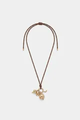 Collar largo con cordón marrón y múltiples dijes dorados colgantes, incluyendo forma de corazón, esfera estriada y otros detalles metálicos.