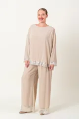 Blusa italiana de gasa color fucsia, con escote redondo y mangas largas acampanadas. Presenta apliques de lentejuelas al tono en el ruedo y los puños.