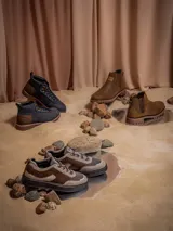 Botines de cuero color azul marino con detalles en cuero marrón en el talón. Presentan un diseño inspirado en Star Wars con el logo grabado en el talón y el Halcón Milenario en el lateral. Cuentan con cordones oscuros, ojales metálicos dorados y una suela robusta de goma en tono tierra.