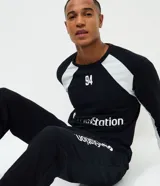 Pijama masculino compuesto por remera de manga larga con cuello redondo y pantalón largo tipo jogger. El conjunto presenta un diseño en color negro con detalles en blanco y estampados oficiales de la marca PlayStation.