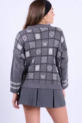 Campera tejida en jacquard con diseño gráfico de tableros, cuello polo y cierre frontal doble. Presenta mangas largas y bolsillos delanteros.