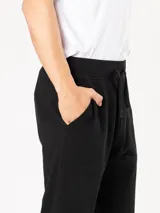 Pantalón de jogging gris claro, corte babucha, con cintura elástica ajustable con cordón.