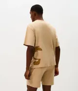 Pijama corto de algodón en color beige, compuesto por remera de manga corta con corte boxy y gran estampa frontal del Coyote de Looney Tunes, y bermuda haciendo juego con estampado lateral.