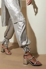 Sandalias plateadas de cuero nobuk, con tiras finas cruzadas en el empeine y tobillo, ajuste de pulsera y taco cuadrado de 7 cm.